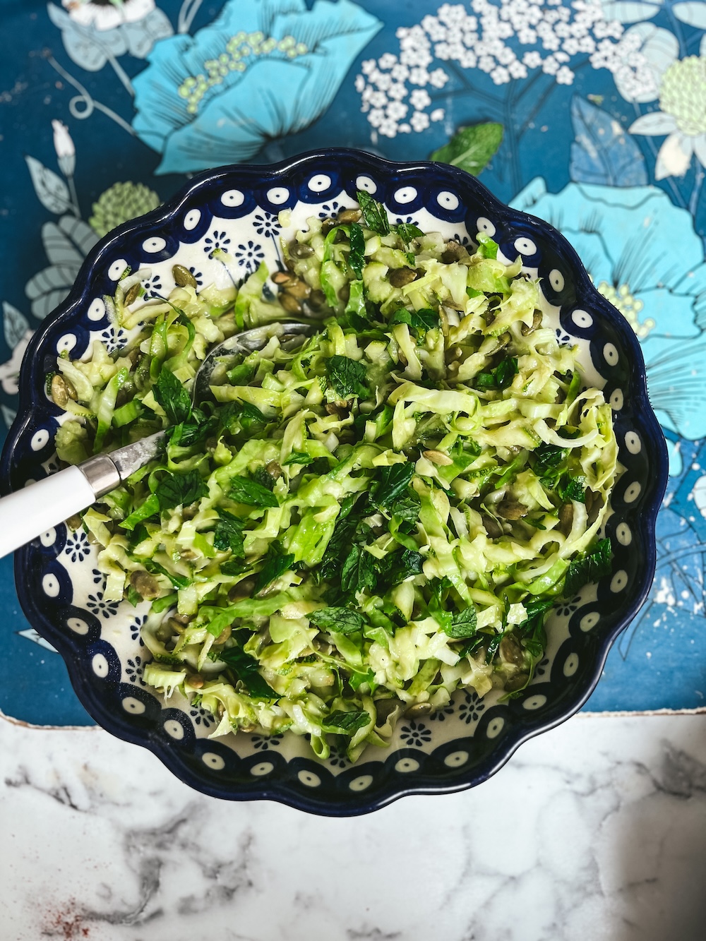 Green slaw with courgette, summer greens and pumpkin seeds with avocado dressing